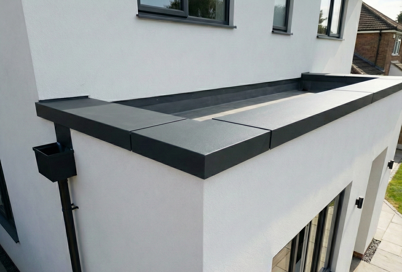 Aluminium wall coping on a parapet wall on a single storey extension.